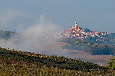 The vineyards in front of the little village of Grana Monferrato. The fog of the morning raises from the fields, Monferrato, Piedmont, Italy, Europe
