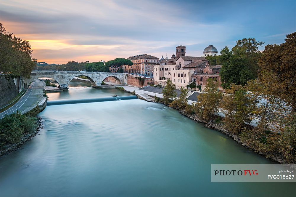 Beautiful and sweet sunset near the tiber Island. The Tiber Island is the only island in the Tiber river which runs through Rome and and has been connected with bridges to both sides of the river since antiquity