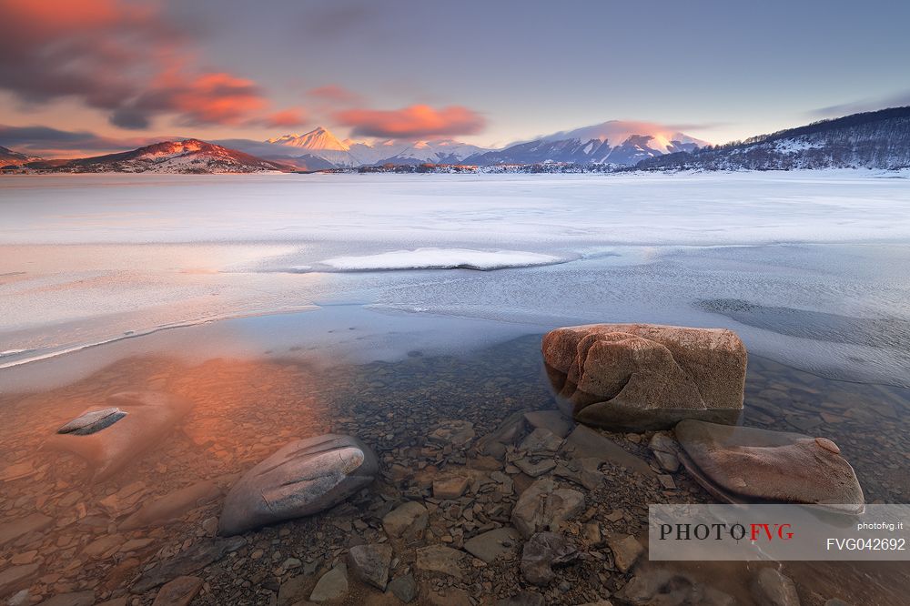 The lake of Campotosto at sunset in late winter during the thawing of the surface of the lake, Gran Sasso national park, Abruzzo, Italy, Europe