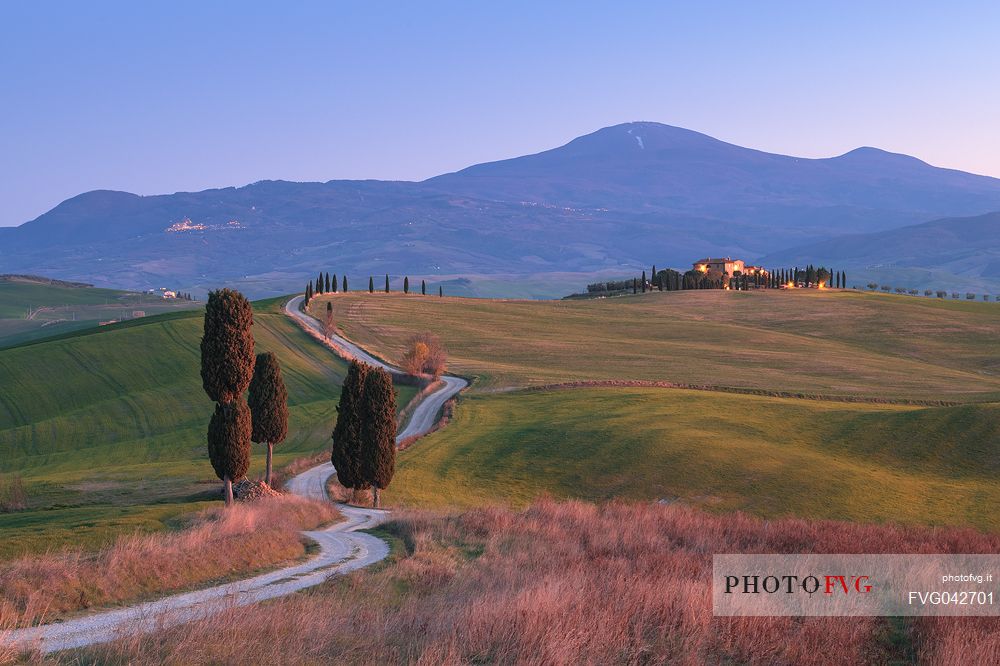 Typical view of Val d'Orcia valley in Tuscany at twilight, with farm and cypresses, Pienza, Italy, Europe