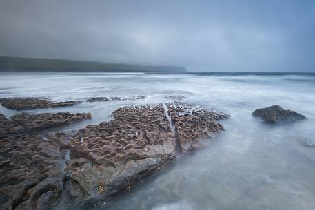 The Doolin's Pier during a storm with the cliffs of Moher in the background