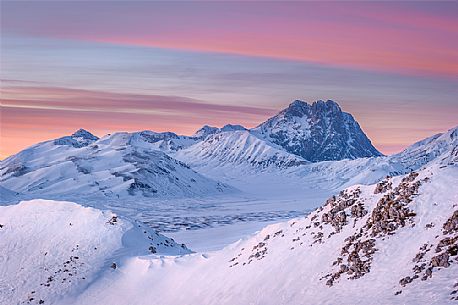 the Corno Grande Peak beyond the Mount Bolza's ridge, in Campo Imperatore, during a beautiful coloured sunset the Corno Grande Peak beyond the Mount Bolza's ridge, in Campo Imperatore, during a beautiful coloured sunset