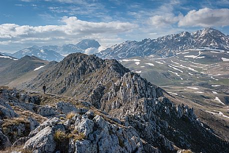 a hiker walks on the crest of Mount Bolza in the plateau of Campo Imperatore, Gran Sasso national park, Abruzzo, Italy, Europe