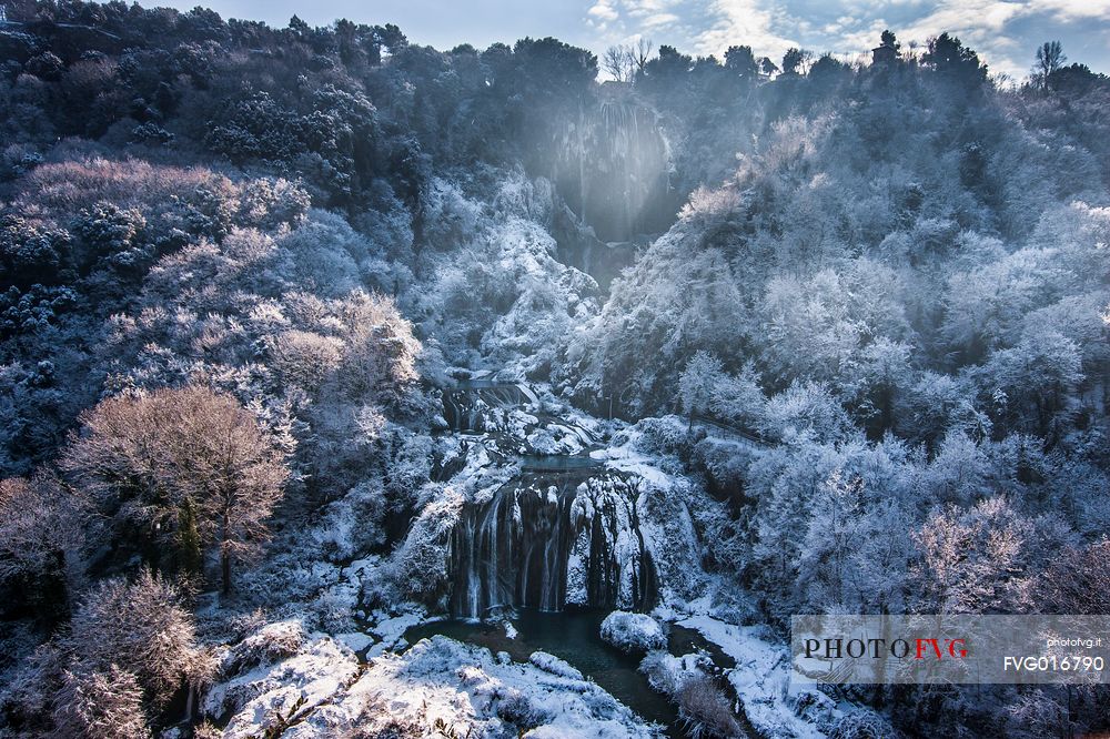 The Marmore waterfall in winter, surrounded by woods with ice and galaverna

