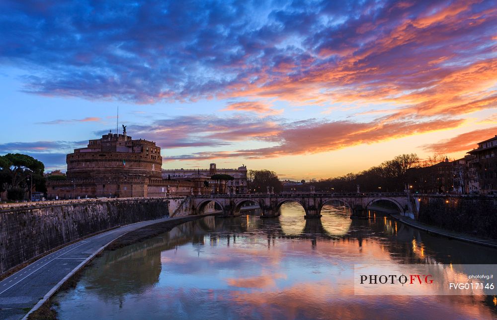 A colored dawn with the reflex of the sky on the river Tevere and the silohuette of Castel Sant'Angelo and the Sant'Angelo bridge