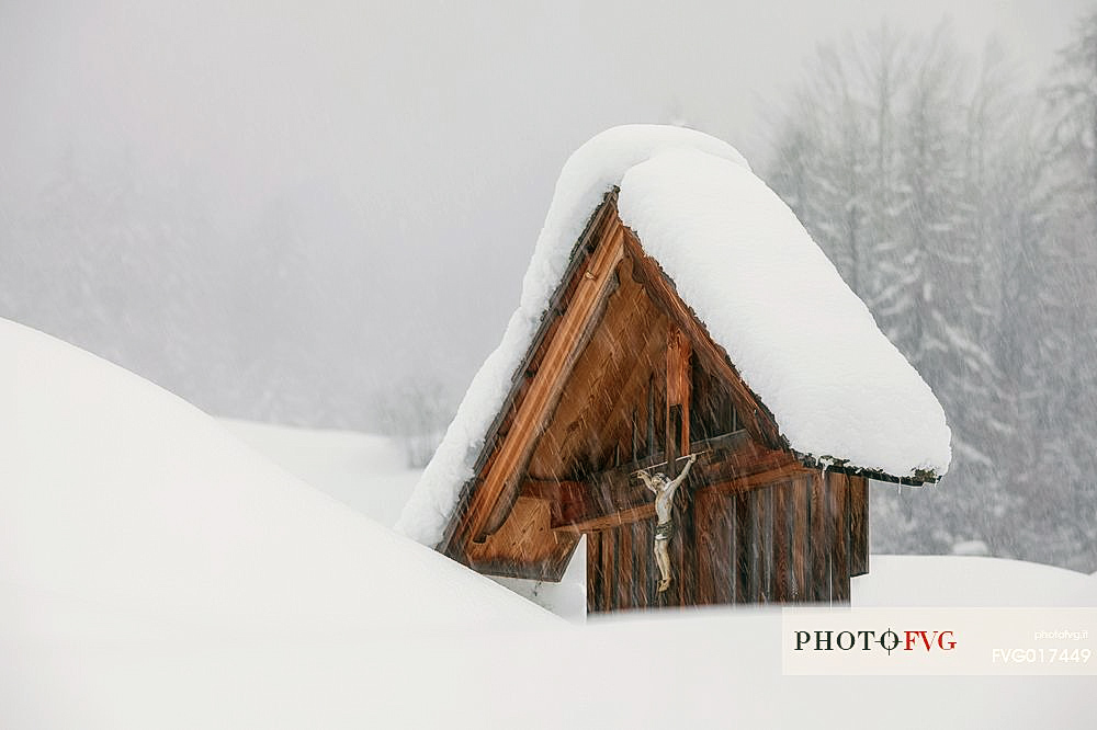 Wooden crucifix during a snowfall