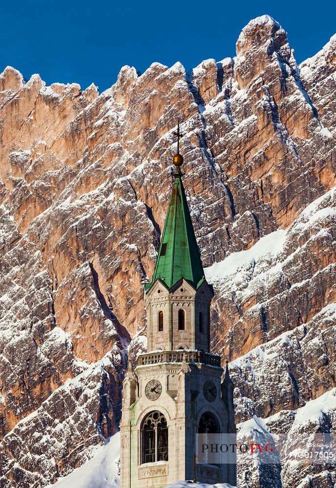 A view of Cortina D'Ampezzo with cathedral's bell tower; in the background mount Pomaganon