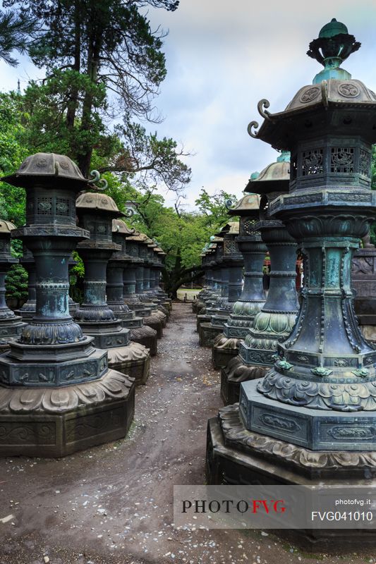 Alley with bronze lanterns to the Tōshō-gū Shinto or Toshogu shrine temple in Ueno park, Tokyo, Japan