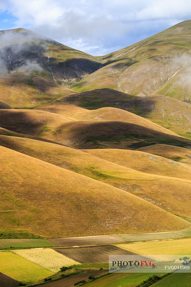 Rolling hills and lentil fields in Castelluccio di Norcia in summer, Sibillini national park, Umbria, Italy, Europe