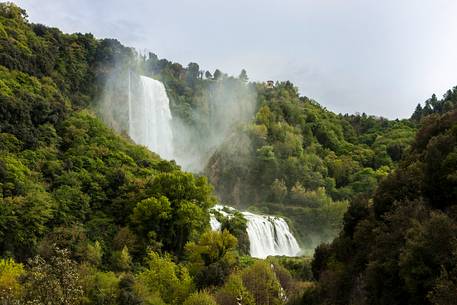 The Marmore waterfall in springtime, surrounded by green woods
