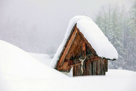 Wooden crucifix during a snowfall