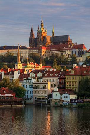 Prague, view across Vltava River and Charles Bridge towards Hradcany Castle and St. Vitus Cathedral at sunrise

