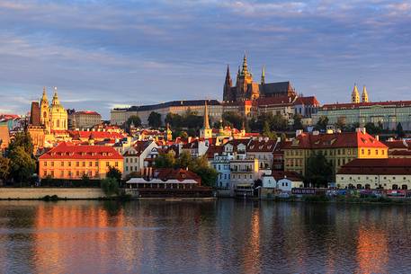 Prague, view across Vltava River and Charles Bridge towards Hradcany Castle and St. Vitus Cathedral at sunrise

