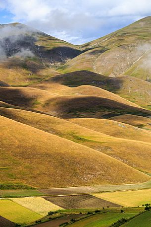 Rolling hills and lentil fields in Castelluccio di Norcia in summer, Sibillini national park, Umbria, Italy, Europe