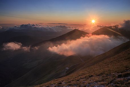 Sunset from the top of Pizzo Tre Vescovi peak, view of Fargno hut and Ussita valley, Sibillini national park, Marche, Italy, Europe