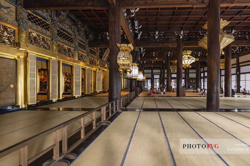 Praying people inside Nishi Hongan-ji. Temple, school of Pure Land Buddhism and Unesco World heritage, Kyoto, Japan