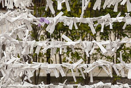 O-mikuji are random fortunes written on strips paper to know own fate at Shinto shrines and Buddhist temple, Fushimi Inari Taisha Shinto Temple, Kyoto, Japan O-mikuji are random fortunes written on strips paper to know own fate at Shinto shrines and Buddhist temple, Fushimi Inari Taisha Shinto Temple, Kyoto, Japan