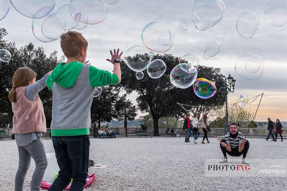 A street artist make soap bubbles for children in Pincio's terrace.