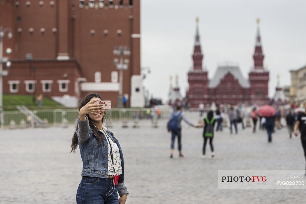 A young girl taking a selfie in the Red Square in Moscow, Russia