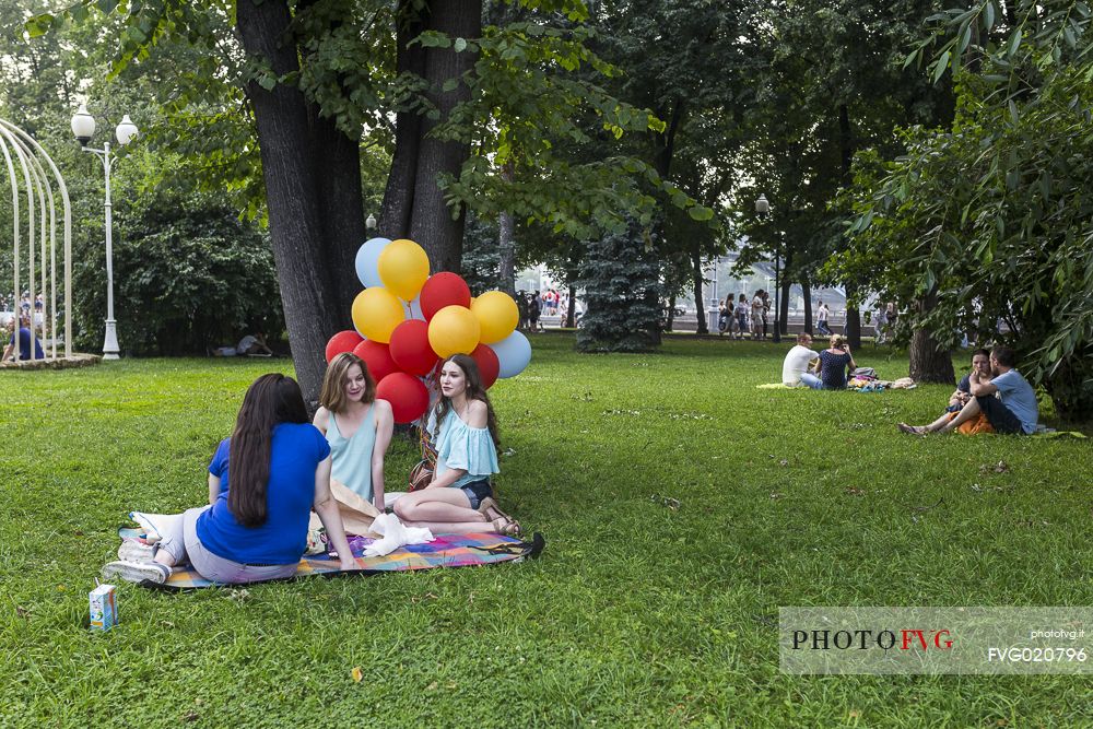 Girls sitting on a blanket in Gorky Park with some colored balloons, Moscow, Russia