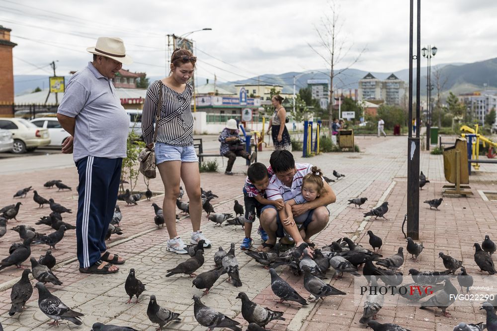 Some people playing with pigeons in front of Gandantegchinlen Khiid monastery, Mongolia