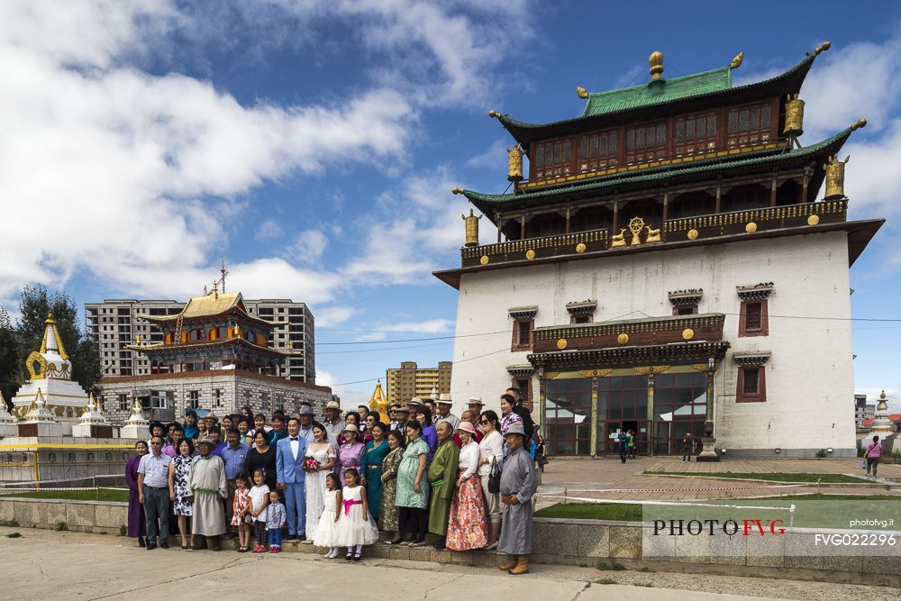 Some people are taking a group photo during a mongolian wedding in front of the Gandantegchinlen Khiid monastery, Mongolia