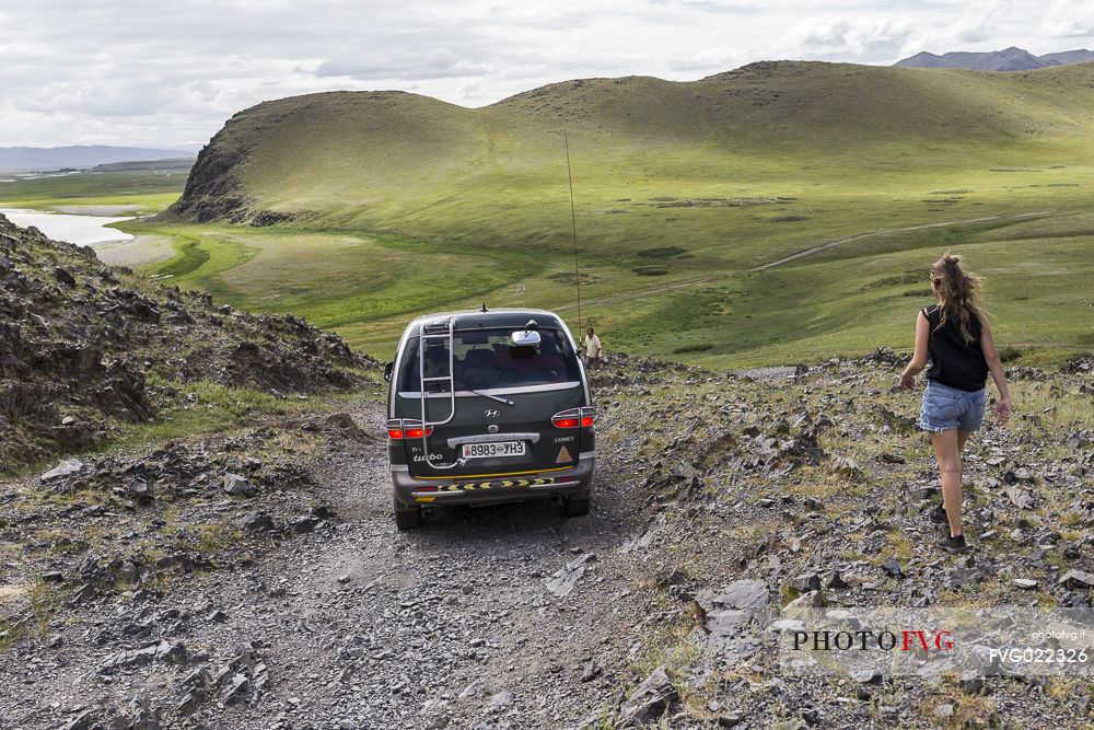 Car going downhill in the mongolian steppe, Mongolia