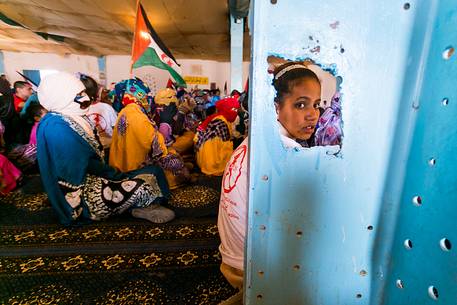A young girl sitting on the floor during a meeting in the refugee camp of Dahkla A young girl sitting on the floor during a meeting in the refugee camp of Dahkla