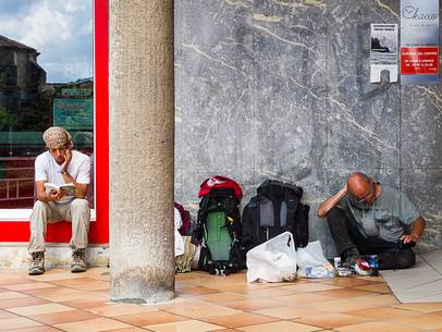 Two pilgrims rest sitting on the floor