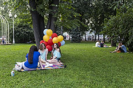 Girls sitting on a blanket in Gorky Park with some colored balloons, Moscow, Russia