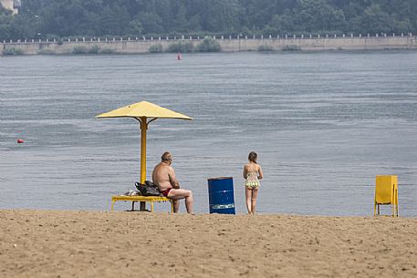 A man and a child relaxing on a siberian beach on the riverside of the river Ob in Novosibirsk, Russia