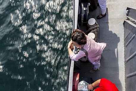 In a ferry a woman looks at the water of Bajkal lake, Siberia, Russia In a ferry a woman looks at the water of Bajkal lake, Siberia, Russia