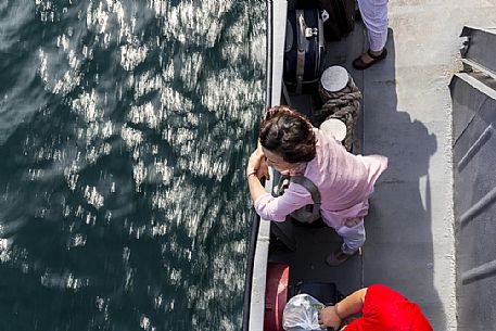 In a ferry a woman looks at the water of Bajkal lake, Siberia, Russia