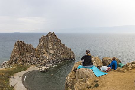 Some people meditating in front of the Shaman's Rock, the holy rock for shamanism in Olkhon Island.