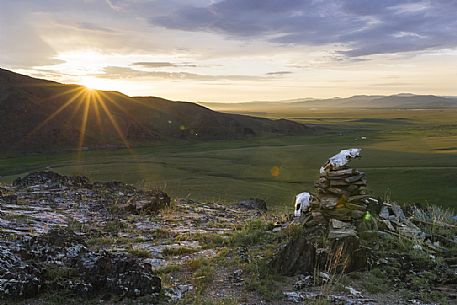 The first light of the sunrise light up 2 skulls of horses put at the top of a hill in the steppe by some nomads in sign of prayer, Mongolia
