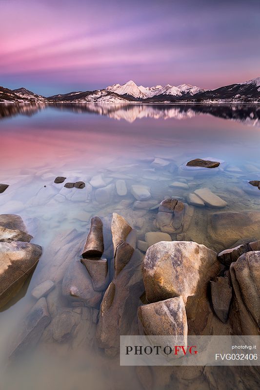 The colors of the sunset light up the lake of Campotosto and the long exposure accentuates the calm and relaxing tones of the nightfall, Gran Sasso and monti della Laga National Park, Abruzzo, Italy