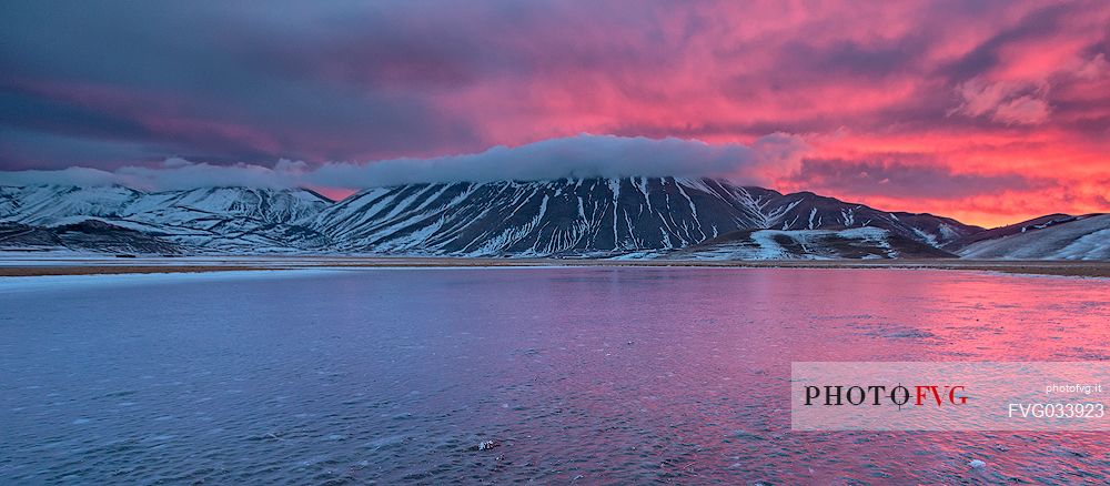 View of the Pian Grande of Castelluccio di Norcia and in the background the Vettore mountain at twilight, Sibillini National Park, Umbria, Italy, Europe