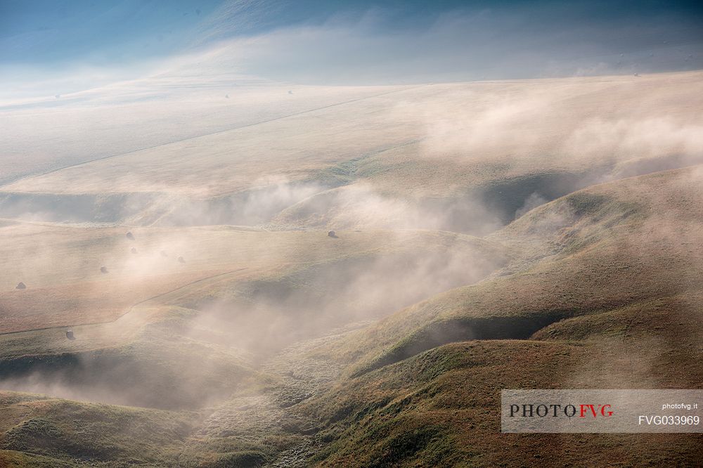 The fog on the plain alternates suggestive views in a slow decline, Castelluccio di Norcia, Sibillini National Park, Italy, Europe