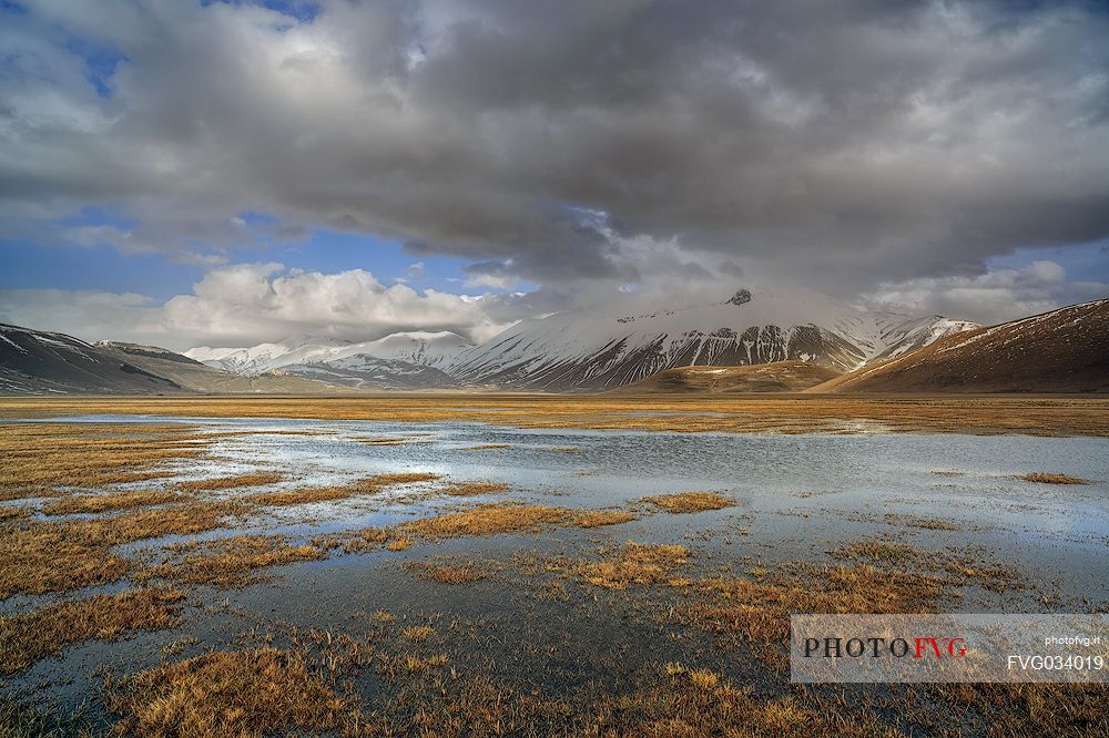 Snow melting in the Pian Grande of Castelluccio di Norcia, in the background the Vettore mountain, Sibillini National Park, Umbria, Italy, Europe