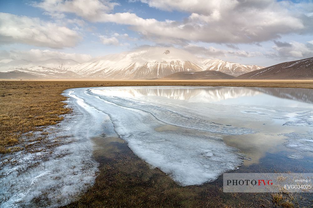 Snow melting in the Pian Grande of Castelluccio di Norcia, in the background the Vettore mountain, Sibillini National Park, Umbria, Italy, Europe