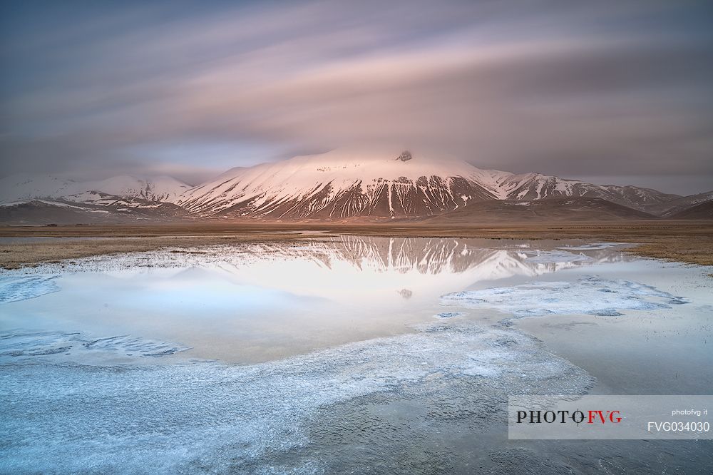 Snow melting in the Pian Grande of Castelluccio di Norcia, in the background the Vettore mountain at dawn, Sibillini National Park, Umbria, Italy, Europe