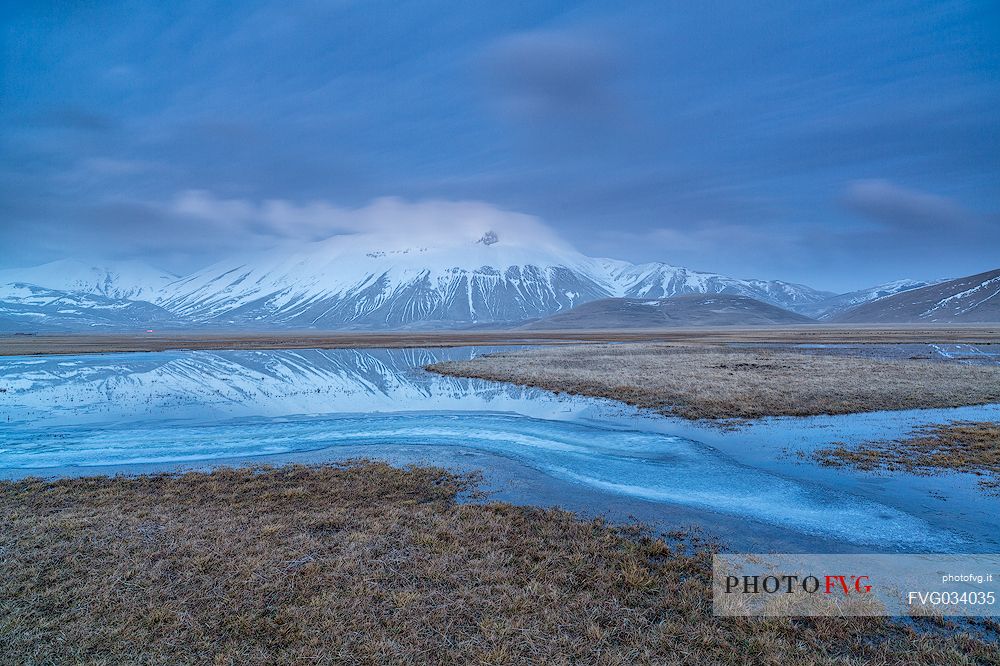 Snow melting in the Pian Grande of Castelluccio di Norcia at twilight, in the background the Vettore mountain, Sibillini National Park, Umbria, Italy, Europe