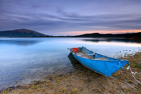 Lonely boat on the shore of Campotosto lake, Gran Sasso and Monti della Laga national park, Abruzzo, Italy Lonely boat on the shore of Campotosto lake, Gran Sasso and Monti della Laga national park, Abruzzo, Italy