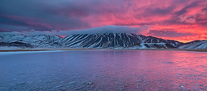 View of the Pian Grande of Castelluccio di Norcia and in the background the Vettore mountain at twilight, Sibillini National Park, Umbria, Italy, Europe