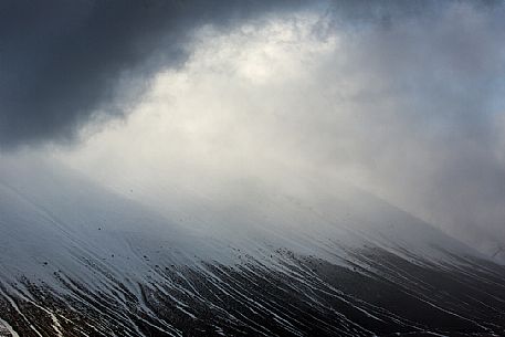 A glimmer of light from the top of the Vettore mountain, Castelluccio di Norcia, Sibillini national park, Umbria, Italy, Europe