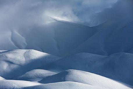 The light that penetrates draws particular shapes on the snowy ground along the road to Mount Prata, Sibillini National Park, Marches, Italy, Europe The light that penetrates draws particular shapes on the snowy ground along the road to Mount Prata, Sibillini National Park, Marches, Italy, Europe