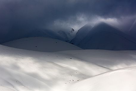The light that penetrates draws particular shapes on the snowy ground along the road to Mount Prata, Sibillini National Park, Marches, Italy, Europe