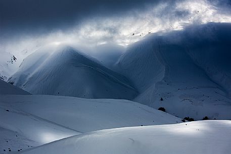 The light that penetrates draws particular shapes on the snowy ground along the road to Mount Prata, Sibillini National Park, Marches, Italy, Europe The light that penetrates draws particular shapes on the snowy ground along the road to Mount Prata, Sibillini National Park, Marches, Italy, Europe