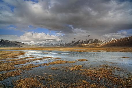 Snow melting in the Pian Grande of Castelluccio di Norcia, in the background the Vettore mountain, Sibillini National Park, Umbria, Italy, Europe