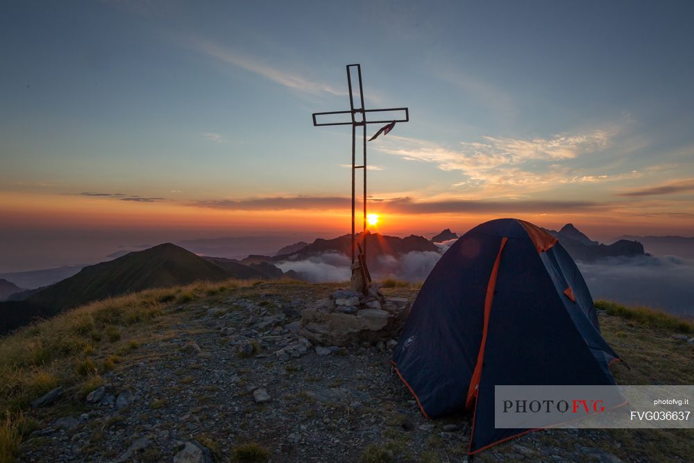 Sunset with tent in the peak of Apuane Alps from Penna di Sumbra mountain peak, Tuscany, Italy, Europe
